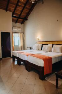 two large beds in a room with at Gimanhala Hotel in Dambulla