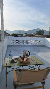 een tafel en een stoel op een balkon met een koffiezetapparaat bij Kan Haven Homestay in Kanchanaburi