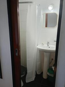 ein weißes Badezimmer mit Waschbecken und Spiegel in der Unterkunft Suite Munro in Munro + 7 Fotos