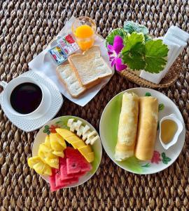 een tafel met twee borden ontbijtproducten en een kopje koffie bij The Cozy House in Karon Beach