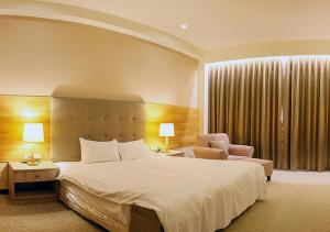 a hotel room with a bed and a chair at Jade Garden Hotel - 翠華會館 in Gukeng +47 photos