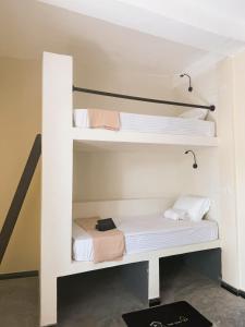 a white bunk bed with white sheets and towels at Nirvana Surf Retreat - Kabalana in Atadahewatugoda