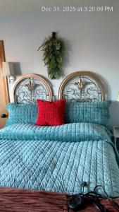 een bed met een blauw dekbed en rode kussens bij Riverhouse Hidden Gem in The Dalles