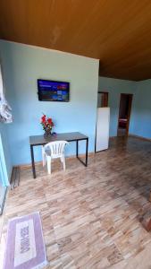 a dining room with a table and a white chair at Paraíso Azul in Ilhéus
