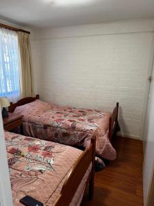 a room with two beds in a room at Los Castaños Pucón in El Cerrillo