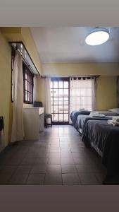 a bedroom with two beds and a large window at Piso entero La Boca in Buenos Aires +8 photos