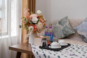 a table with a tray with a vase of flowers at Nagomi Residence in Hanoi