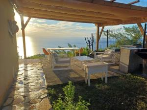 a patio with a table and chairs and the ocean at Kevio in Chambort