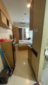 a room with a kitchen and a bedroom with a bed at ANDERSON BENSON CONNECT PAKUWON MAll in Surabaya