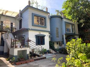 a blue and white house with stairs and plants at Anjali Homestay - 10 mins from Bagdogra airport in Siliguri