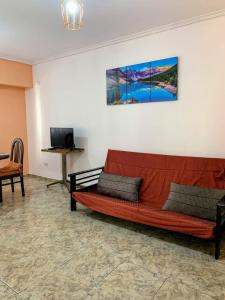 a red couch sitting in a room with a table at Piso entero La Boca in Buenos Aires