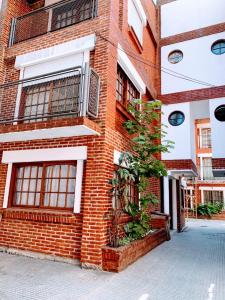 a brick building with a tree in front of it at Piso entero La Boca in Buenos Aires