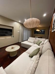 a living room with a white couch and a table at Villa Japandi in Paramaribo