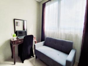 a living room with a chair and a desk with a computer at Royal Sentul Al Alami in Kedungmanggu
