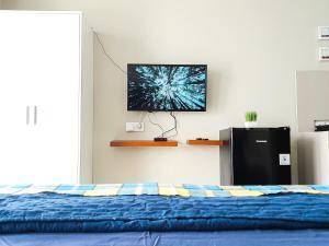 a bedroom with a bed and a tv on the wall at Royal Sentul Al Alami in Kedungmanggu +9 photos