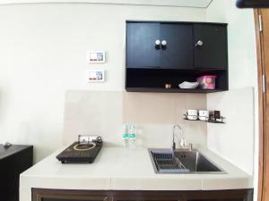 a kitchen counter with a sink and a microwave at Royal Sentul Al Alami in Kedungmanggu