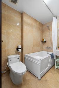 a bathroom with a toilet and a bath tub at Nagomi Residence in Hanoi