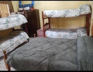 a bedroom with two bunk beds and a gray bed at La Galactica in Salta