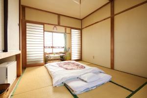 a room with a bed in the corner of a room at 旅館おぎた Ryokan Ogita - near Shiraoi Station in Shiraoi