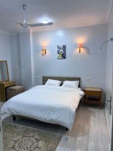 a bedroom with a large white bed with two pillows at Maat apartment in Luxor
