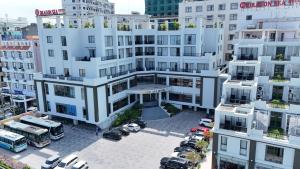 an overhead view of a white building with cars parked in a parking lot at Dragon Sea Sam Son Hotel in Sầm Sơn