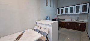 a kitchen with a white counter and chairs in it at Spacious 3BR Villa in Jembrana in Mendaya