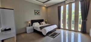 a bedroom with a bed and a large window at Spacious 3BR Villa in Jembrana in Mendaya +46 photos