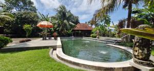 a swimming pool in a yard with a gazebo at Spacious 3BR Villa in Jembrana in Mendaya