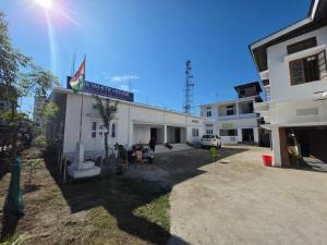 a white building with a sign on the side of it at The White House By Bhaskar Homestay in Dibrugarh