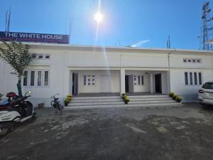a white house with motorcycles parked in front of it at The White House By Bhaskar Homestay in Dibrugarh