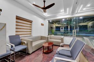 a living room with a couch and chairs and a ceiling fan at Hill Hara in Tirupati