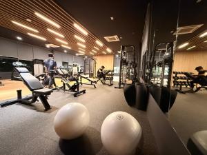a gym with machines and people in the background at Aisy Suite Splash Mania View in Bandar Gamuda Cove