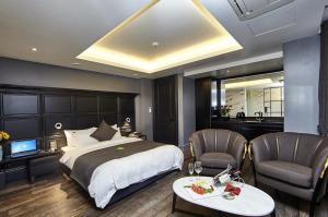 a bedroom with a bed and two chairs and a television at Hotel Soulhada Gangnam in Seoul +46 photos