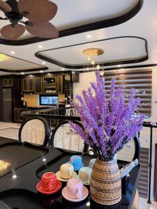 a vase with purple flowers on a table with hats at Cat Ba Cam's Villa in Cat Ba +4 photos
