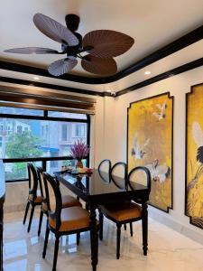 a dining room with a table and a ceiling fan at Cat Ba Cam's Villa in Cat Ba