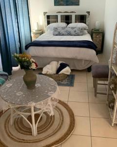 a bedroom with a bed and a table with a vase on it at Vicky holiday home in Walvis Bay