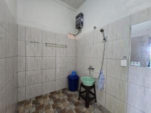 a bathroom with a shower with a stool in it at Keramas Selukat Guest House in Keramas