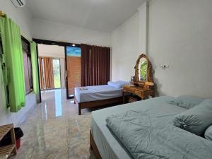 a bedroom with two beds and a mirror at Keramas Selukat Guest House in Keramas