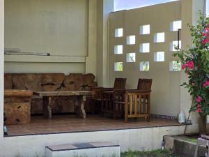 a wooden table and chairs on a patio at Keramas Selukat Guest House in Keramas +28 photos