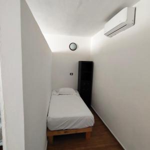 a small room with a bed and a clock on the wall at Casa Aleymar in Playa del Carmen +15 photos