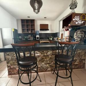 a kitchen with two bar stools at a counter at Casa Aleymar in Playa del Carmen