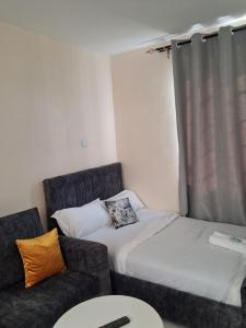 a living room with a couch and a bed at Machakos Town studios in Machakos