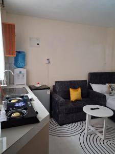 a kitchen and a living room with a couch at Machakos Town studios in Machakos