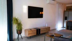 een woonkamer met een tv aan een witte muur bij Villa Luminosa by Villas Guide in Šmrika
