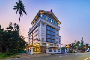 a tall white building with a man on top of it at Classik Fort Inn & Suites in Cochin