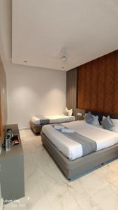 een slaapkamer met 2 bedden en een bureau bij Hotel Kiara Eshosans Palace in Shirdi
