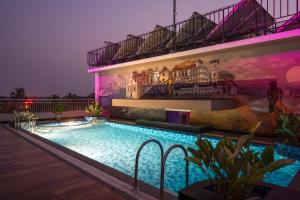 a swimming pool in front of a building at night at Classik Fort Inn & Suites in Cochin