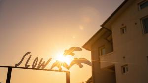 a sign in front of a building with the sun at Yangyang Slowstay Pension in Yangyang +1 photo