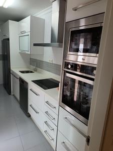 a kitchen with stainless steel appliances and white cabinets at Antonio del Toro in Lora del Río