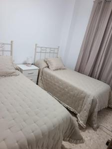two beds sitting next to each other in a bedroom at Antonio del Toro in Lora del Río